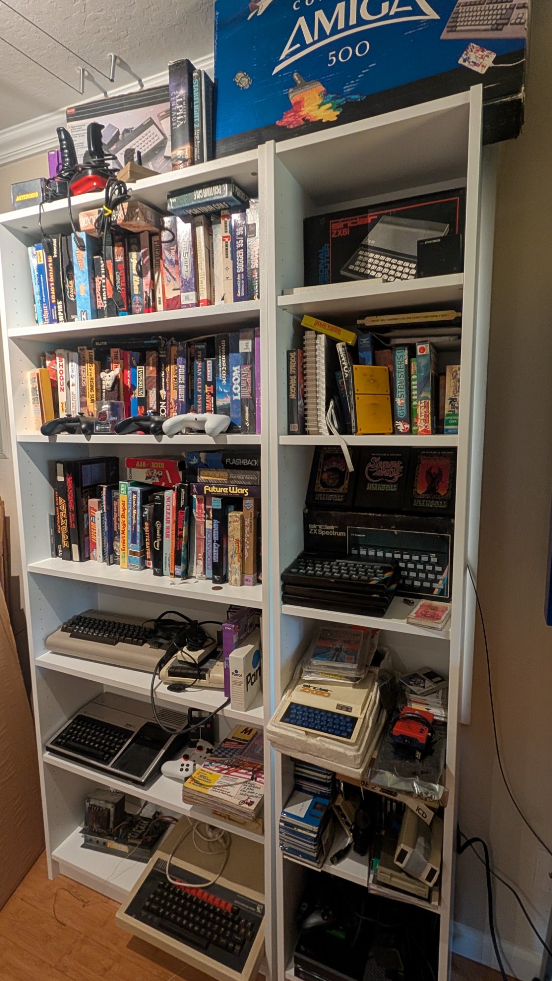 Vintage computer collection with Amiga 500, ZX Spectrum, Commodore 64, and classic 8-bit systems for repair